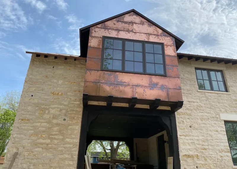 Copper metal panel facade on a stone building for Roof Repair in Silver Firs